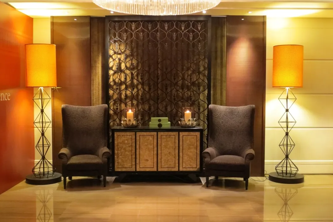 Hotel reception lounge with lamps and armchairs, hotel payment processing systems at the front desk