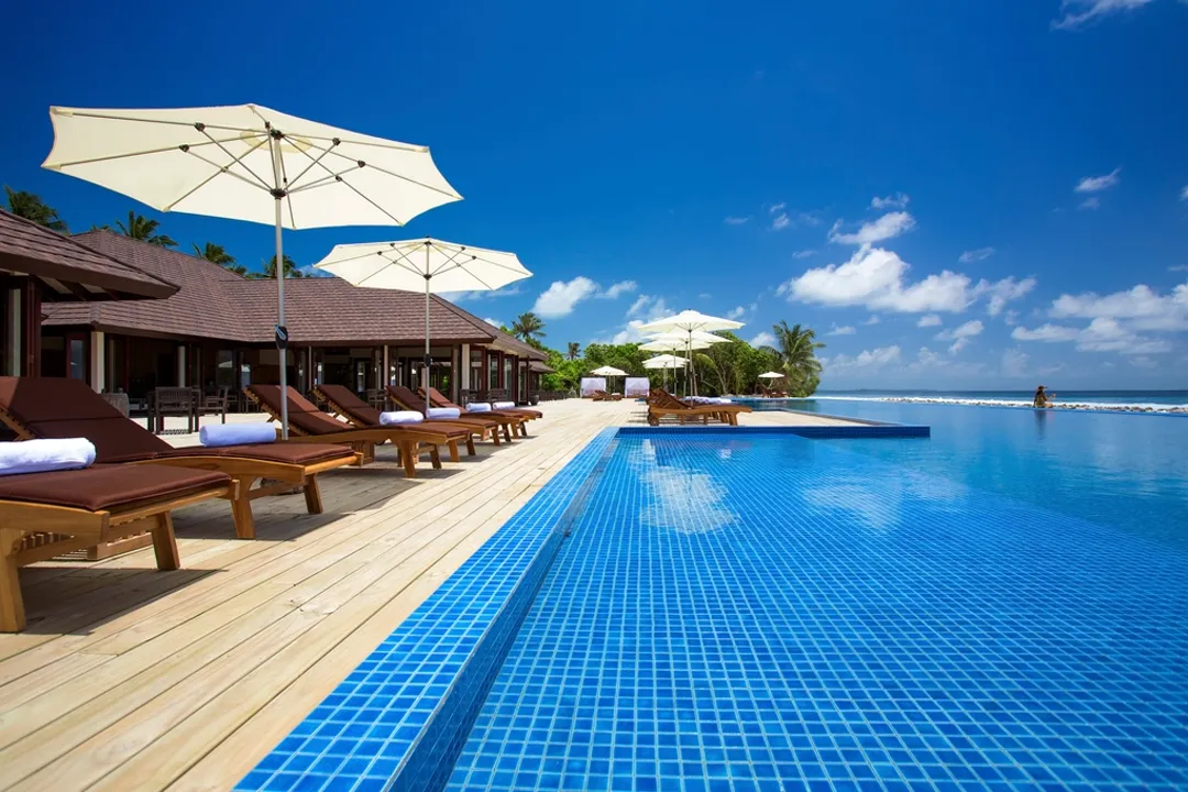 Resort infinity pool with umbrellas, resort payment processing across revenue centers